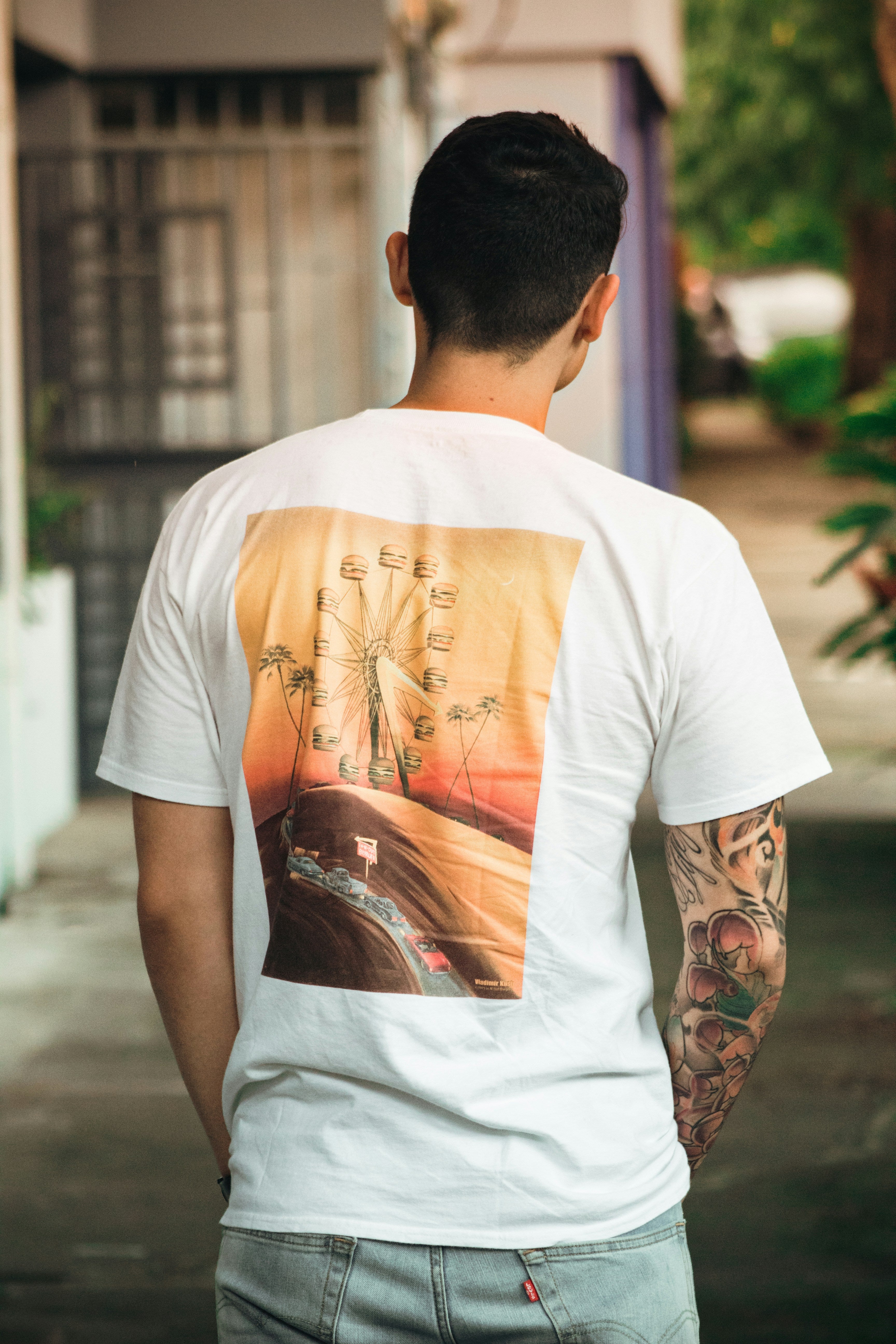 A person wearing a white t-shirt with a watercolor portrait of their dog printed on the front.